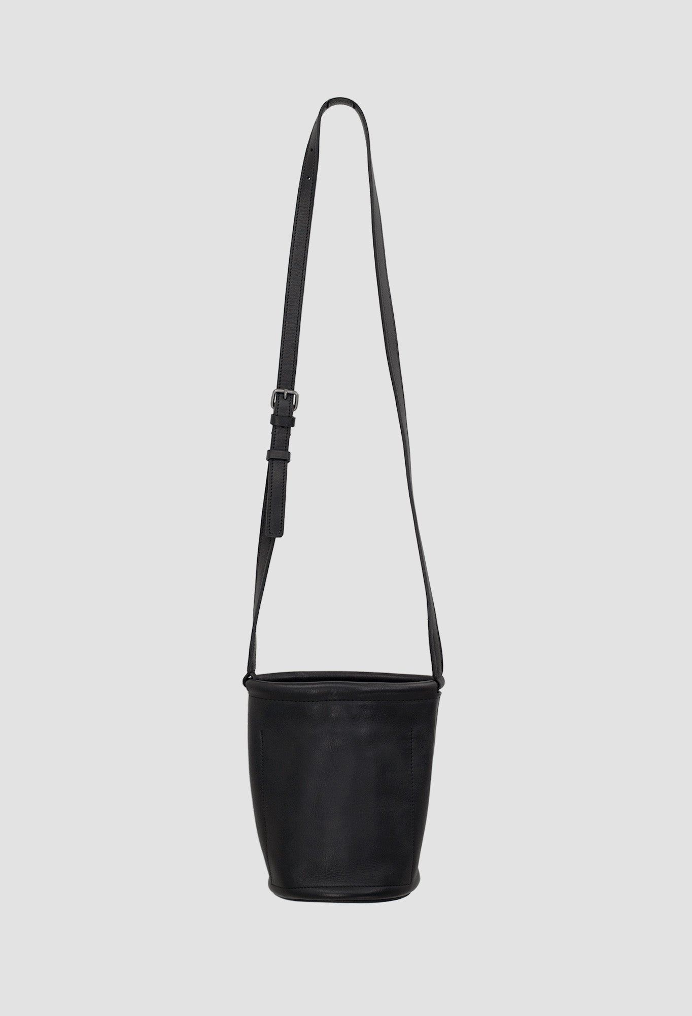 Black shoulder bag with a strap on a light gray background