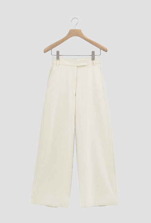White pants on a wooden hanger against a white background