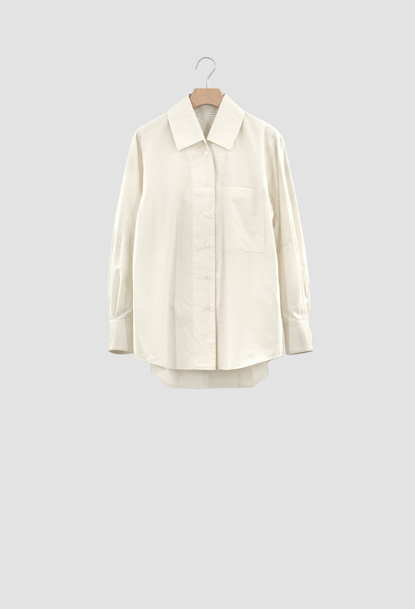White shirt on a hanger against a light gray background