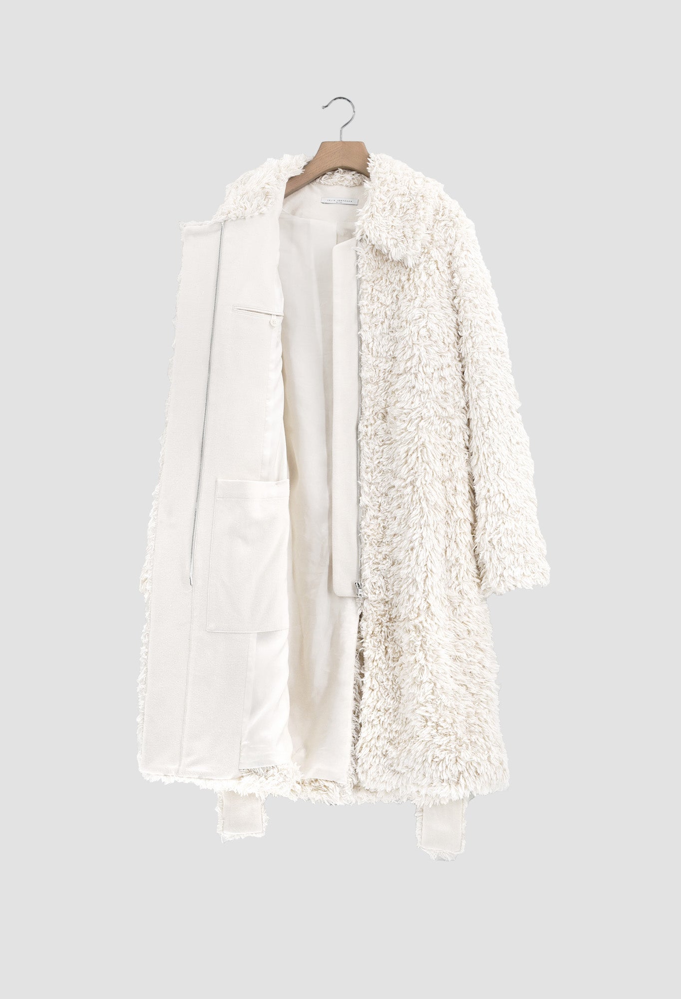 White sherpa coat on a hanger against a light gray background