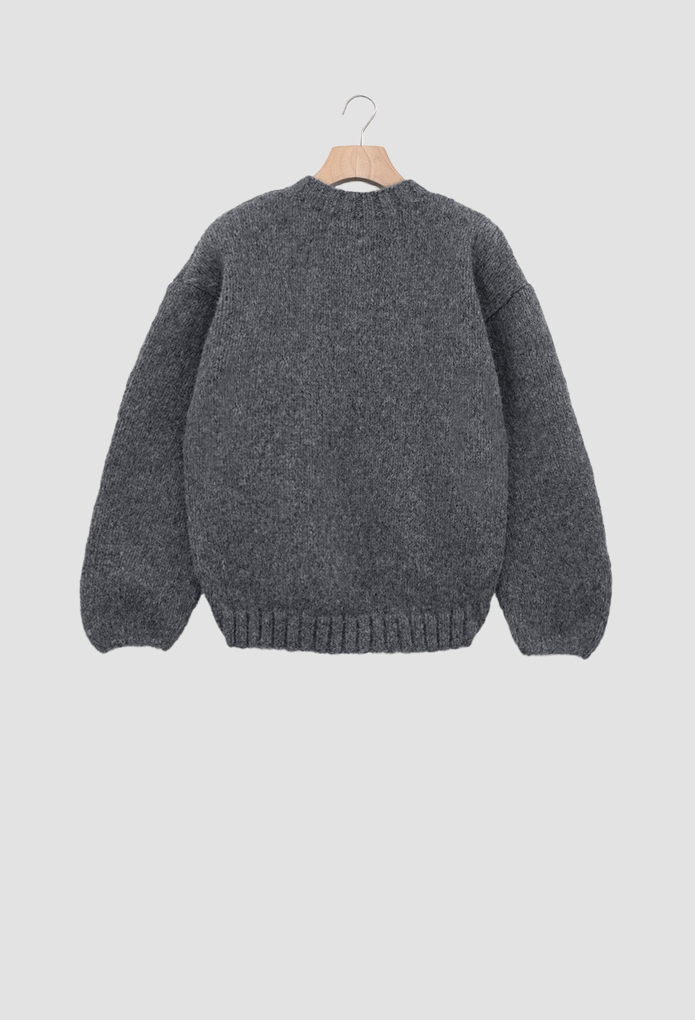 Gray sweater on a hanger against a light gray background