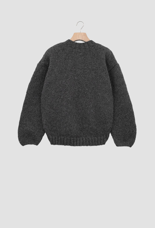 Dark gray sweater on a hanger against a light gray background