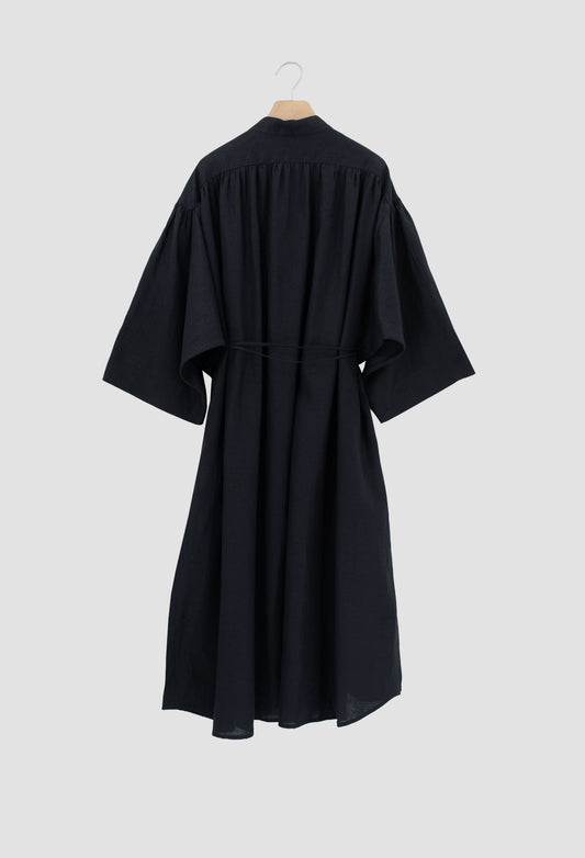 A black kimono-style dress with wide three-quarter sleeves and a self-tie waist belt, shown from the back on a wooden hanger against a light gray background.