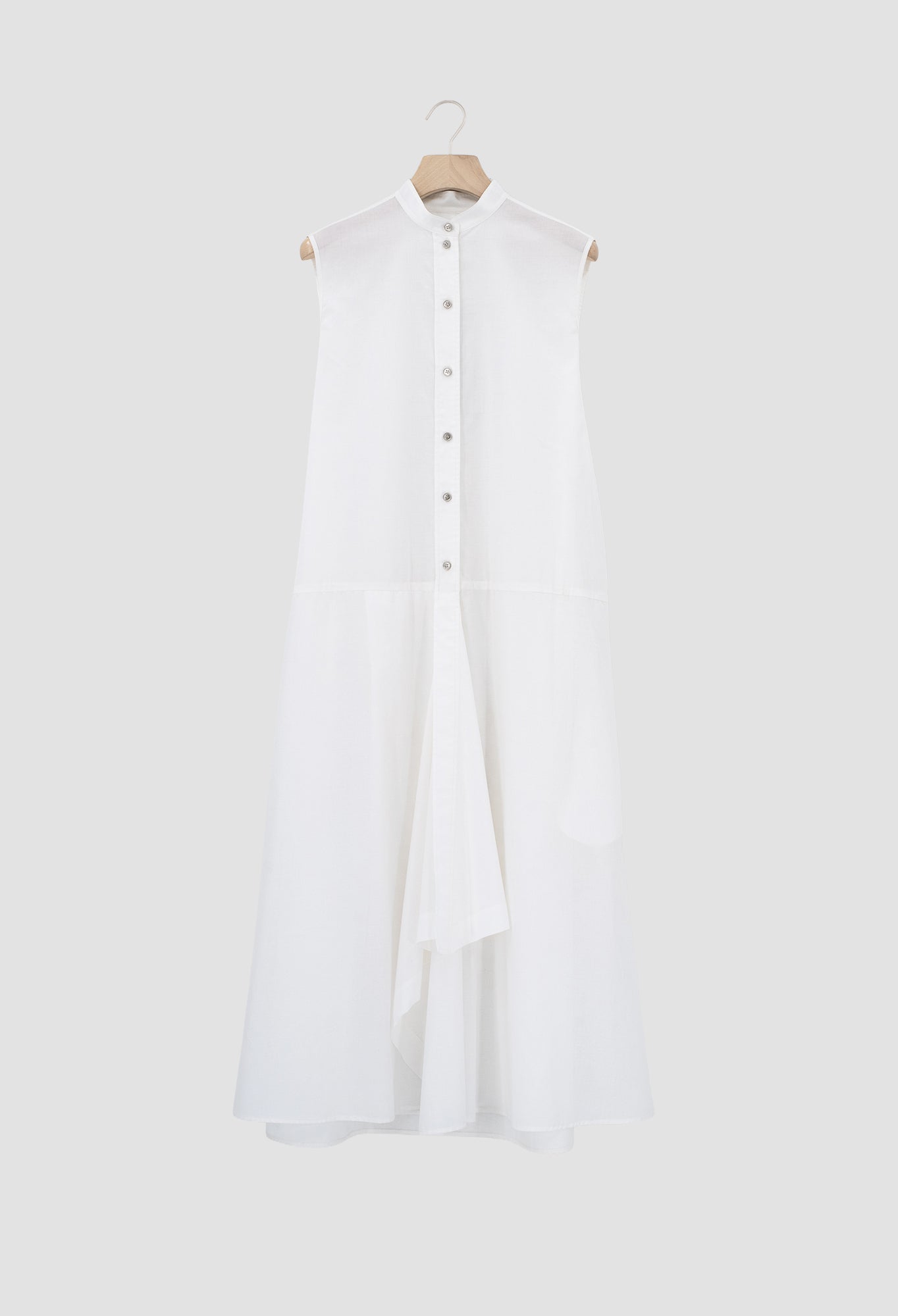 Ivory Sleeveless cotton batiste dress with asymmetrical hem and metal button closures.