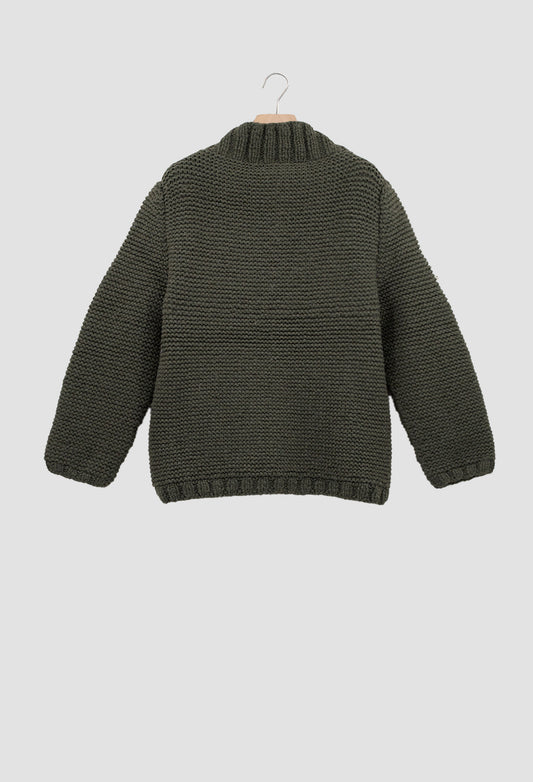 Green knitted sweater on a hanger against a light gray background
