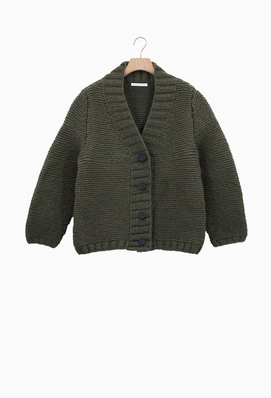 Green knitted cardigan on a hanger against a white background