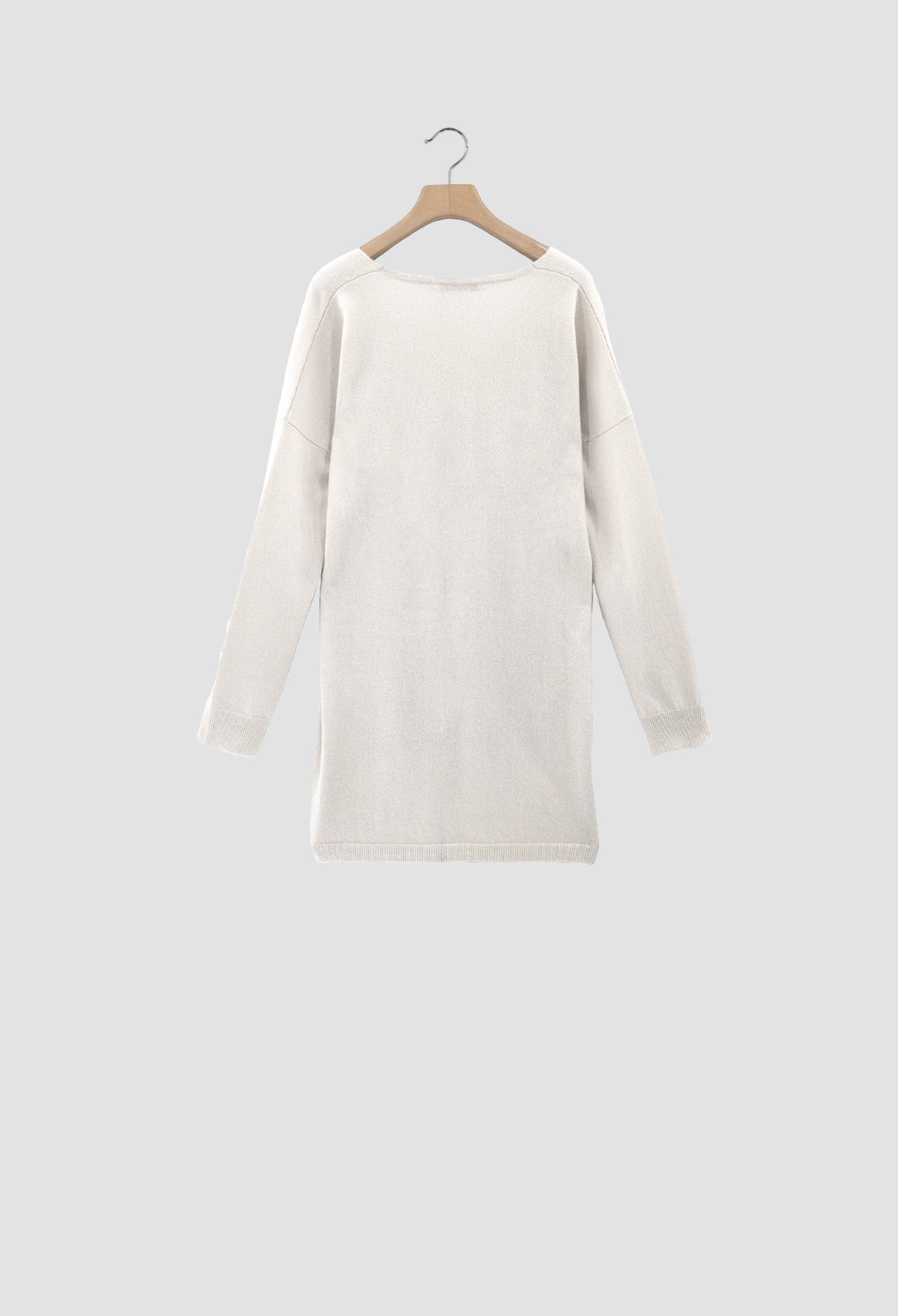 White sweater on a wooden hanger against a light gray background