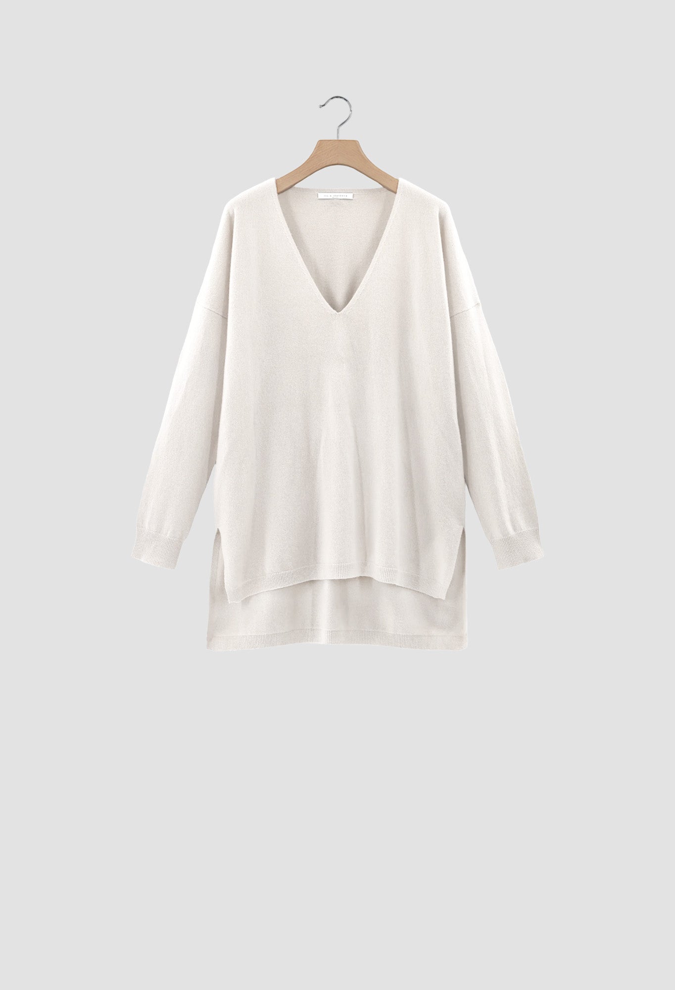 White V Neck sweater on a hanger against a light gray background