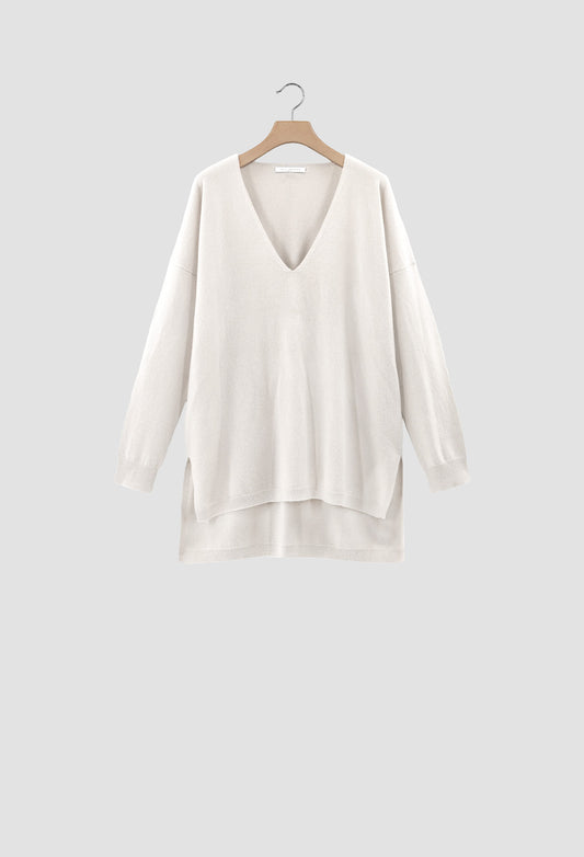 White V Neck sweater on a hanger against a light gray background