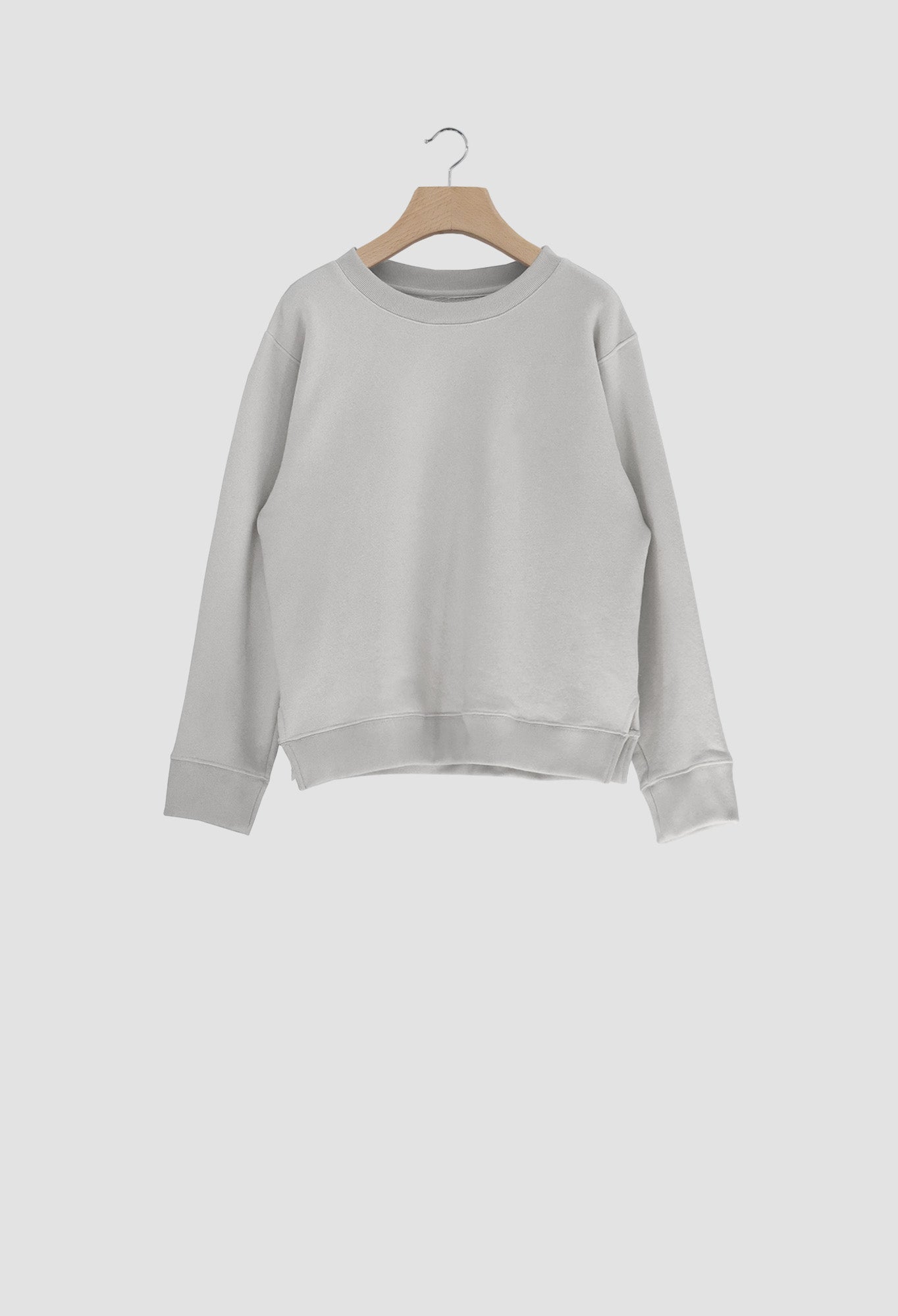 Gray sweatshirt on a wooden hanger against a white background