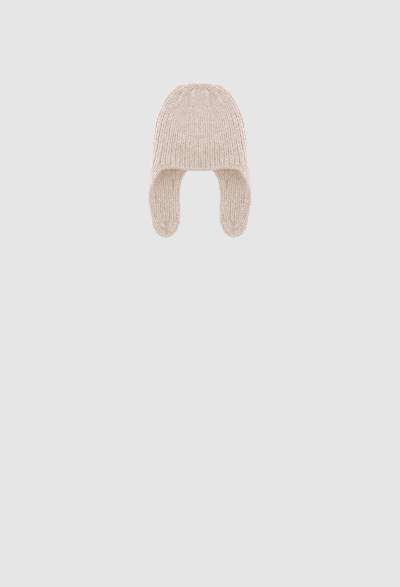 Beige knitted baby hat on a light gray background
