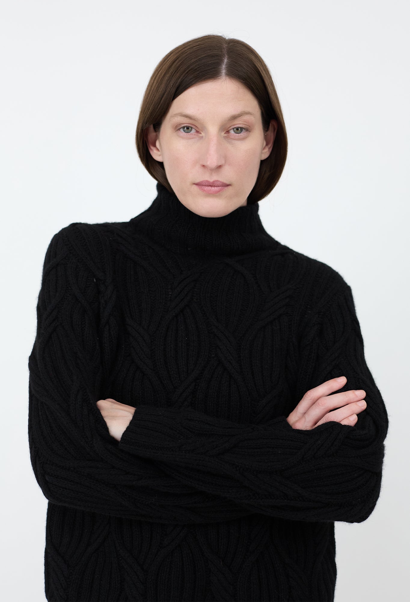 Person wearing a black turtleneck sweater against a white background