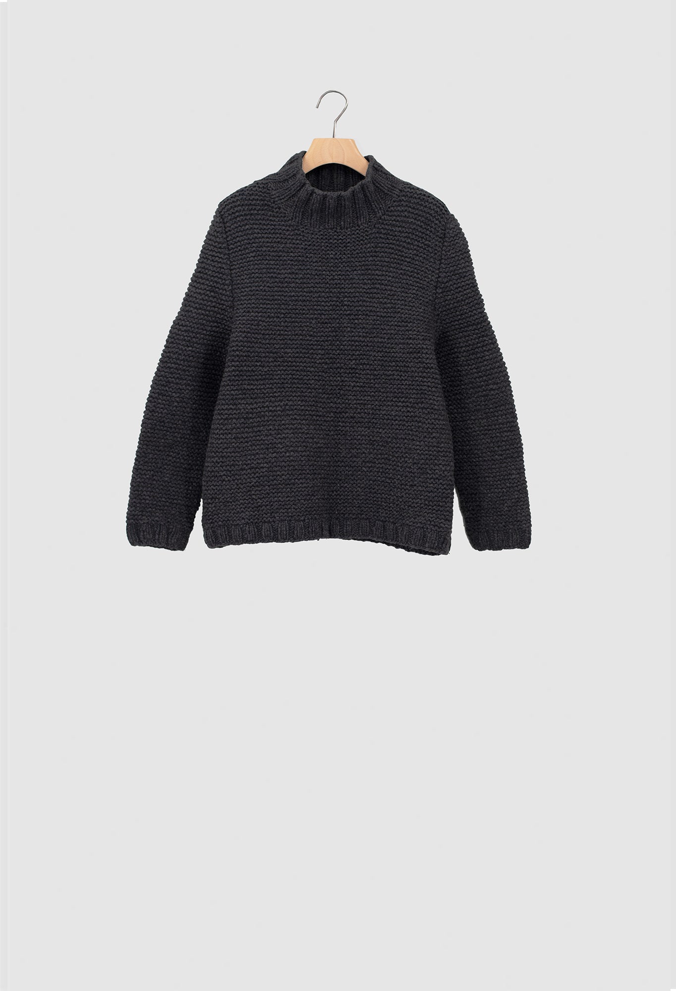 Dark gray sweater on a hanger against a light gray background