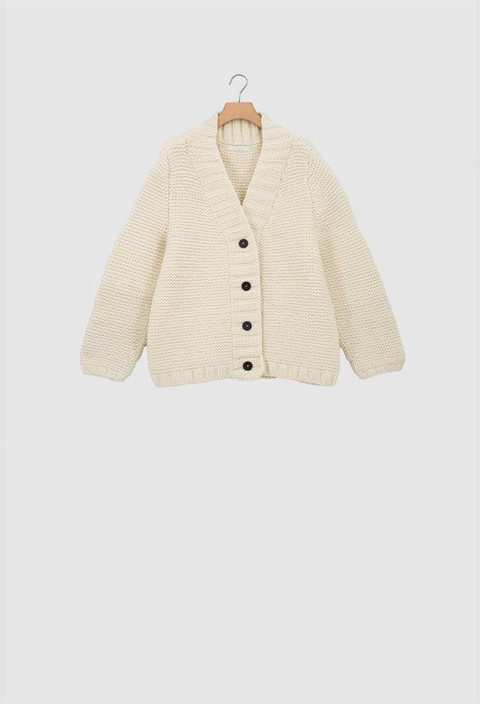 Beige cardigan on a hanger against a white background